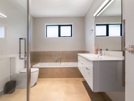 A bathroom with a sink and a bath tub at Bay View Escape - Cable Bay