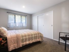 A bedroom with a bed and window at Bay View Escape - Cable Bay