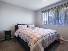 A bedroom with a bed and window at Bay View Escape - Cable Bay Holiday Home