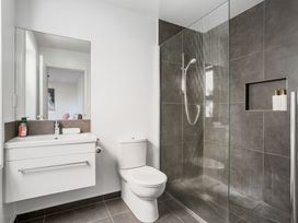 A bathroom with a shower and sink at Sun & Surf Stay - Papamoa Holiday Home