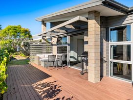 An outdoor area with seating and barbecue at Sun & Surf Stay - Papamoa Holiday Home