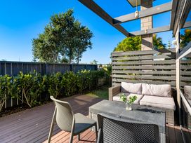 A patio with a sofa and coffee table at Sun & Surf Stay - Papamoa Holiday Home