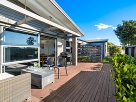 An outdoor seating area with table and chairs at Sun & Surf Stay - Papamoa Holiday Home
