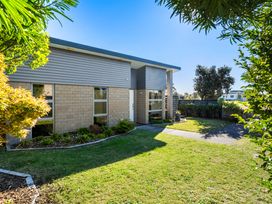 A house with a landscaped garden and pathway at Sun & Surf Stay - Papamoa Holiday Home