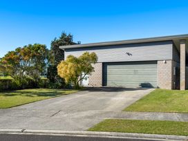 A house with a garage and driveway at Sun & Surf Stay - Papamoa Holiday Home