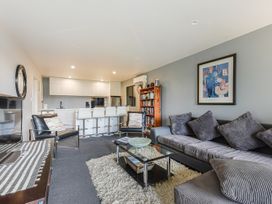 A living room with seating and a kitchen area at The Sounds Hideaway - Moetapu Bay