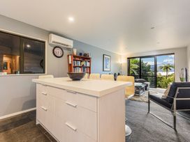 A living room with a kitchen island and a bookshelf at The Sounds Hideaway - Moetapu Bay