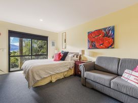 A bedroom with a bed and sofa at The Sounds Hideaway - Moetapu Bay
