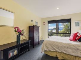 A bedroom with a bed, dresser and window at The Sounds Hideaway - Moetapu Bay