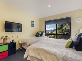 A bedroom with two beds and a television at The Sounds Hideaway - Moetapu Bay