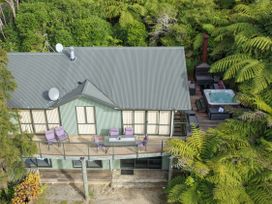 An outdoor area with a hot tub, chairs, and table at The Sounds Hideaway - Moetapu Bay