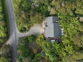 An aerial view of a house surrounded by trees and a road at The Sounds Hideaway - Moetapu Bay