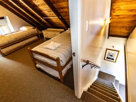 A bedroom with beds and a staircase at Scottbase - Waimarino