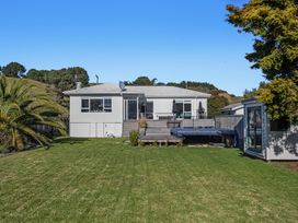 A house with a deck and swimming pool in the garden at Ocean Breeze Escape - Ohope Holiday Home