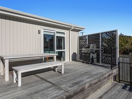 An outdoor area with a table, bench, and grill at Ocean Breeze Escape - Ohope Holiday Home