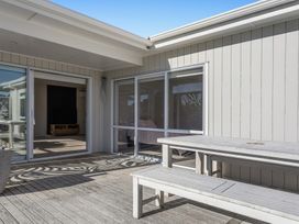 An outdoor area with a table and benches at Ocean Breeze Escape - Ohope Holiday Home