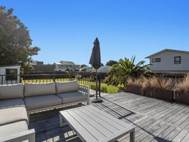 A seating area with a table and umbrella at Ocean Breeze Escape - Ohope Holiday Home