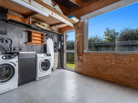 A laundry room with washing machine and dryer at Ocean Breeze Escape - Ohope Holiday Home