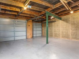 A garage with a garage door and a support beam at Ocean Breeze Escape - Ohope Holiday Home