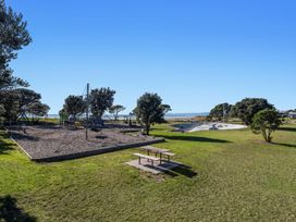 A playground with climbing structure and picnic table at Ocean Breeze Escape - Ohope Holiday Home