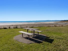 A picnic table near the beach at Ocean Breeze Escape - Ohope Holiday Home