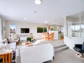 A living room with a sofa and dining area at Lola's - Cambridge Holiday Home in Morrinsville