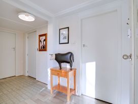 A hallway with a cow statue on a table at Lola's - Cambridge Holiday Home in Morrinsville