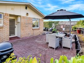 An outdoor seating area with a table and chairs at Lola's - Cambridge Holiday Home in Morrinsville