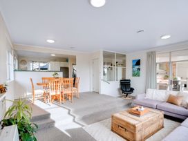 A living room with a dining table and chairs and a sofa at Lola's - Cambridge Holiday Home in Morrinsville