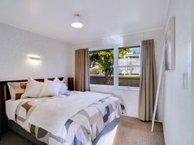 A bedroom with a bed and window at Lola's - Cambridge Holiday Home in Morrinsville