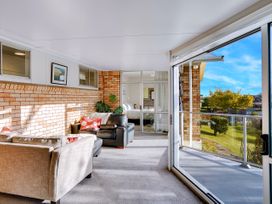 A sunroom with sofas and windows at Lola's - Cambridge Holiday Home in Morrinsville