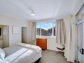 A bedroom with a bed and wooden drawers at Lola's - Cambridge Holiday Home, Morrinsville