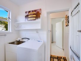 A laundry room with a washing machine and sink at Lola's - Cambridge Holiday Home, Morrinsville