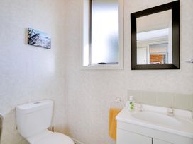 A bathroom with a toilet and sink at Lola's - Cambridge Holiday Home in Morrinsville