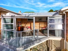An outdoor area with a balcony and sliding glass door at Lola's - Cambridge Holiday Home, Morrinsville
