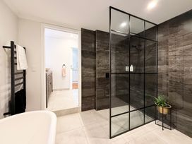 A bathroom with a shower and bathtub at Country Idyll II – Sandspit Holiday Cottage, Warkworth