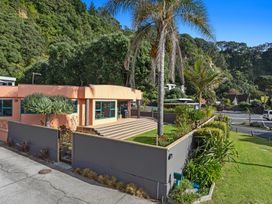 An outdoor view of a house with a garden at The Lights House - Beachfront Ohope Holiday Home Ohope