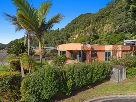 A house with palm trees and bushes at The Lights House - Beachfront Ohope Holiday Home Ohope