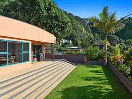 An outdoor area with a deck and garden at The Lights House - Beachfront Ohope Holiday Home Ohope