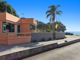 A house with windows and a door at The Lights House - Beachfront Ohope Holiday Home Ohope