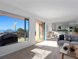 A living room with a sofa and a table at The Lights House - Beachfront Ohope Holiday Home Ohope