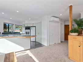 A kitchen with appliances and cabinets at The Lights House - Beachfront Ohope Holiday Home in Ohope