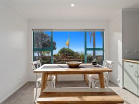 A dining room with a table and chairs at The Lights House - Beachfront Ohope Holiday Home Ohope