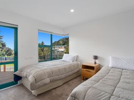 A bedroom with two beds and a nightstand at The Lights House - Beachfront Ohope Holiday Home Ohope