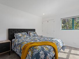 A bedroom with a bed and nightstand at The Lights House - Beachfront Ohope Holiday Home Ohope