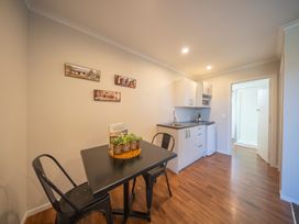 A kitchen with table and chairs at Mustering - Te Anau Holiday Home in Te Anau