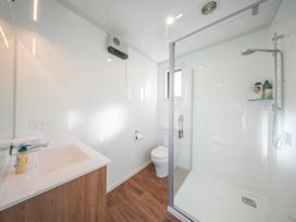 A bathroom with a sink, toilet, and shower at Mustering - Te Anau Holiday Home Te Anau