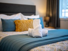 A bedroom with towels arranged on a bed at Mustering - Te Anau Holiday Home in Te Anau