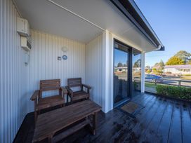 An outdoor patio area with wooden chairs and a table at Mustering - Te Anau Holiday Home, Te Anau