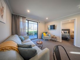 A living room with a sofa and a television at Dusky Hunting Unit - Te Anau Holiday Home Te Anau
